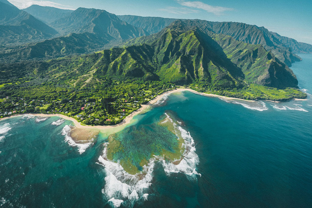 Aerial view of mountains and turquoise ocean in Hawaii